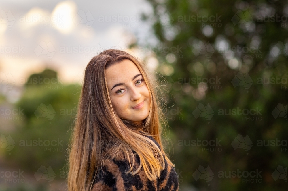 teenage girl with long hair looking over her shoulder - Australian Stock Image