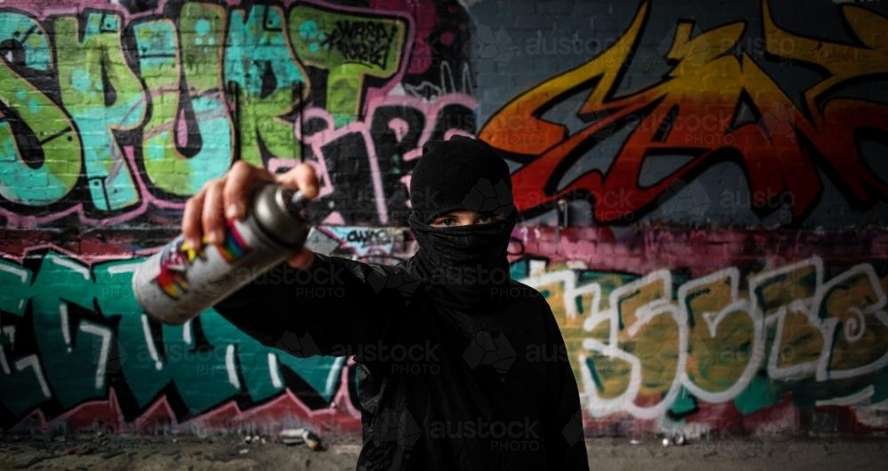 Image of Teenage graffiti artist with spray can in hand - Austockphoto