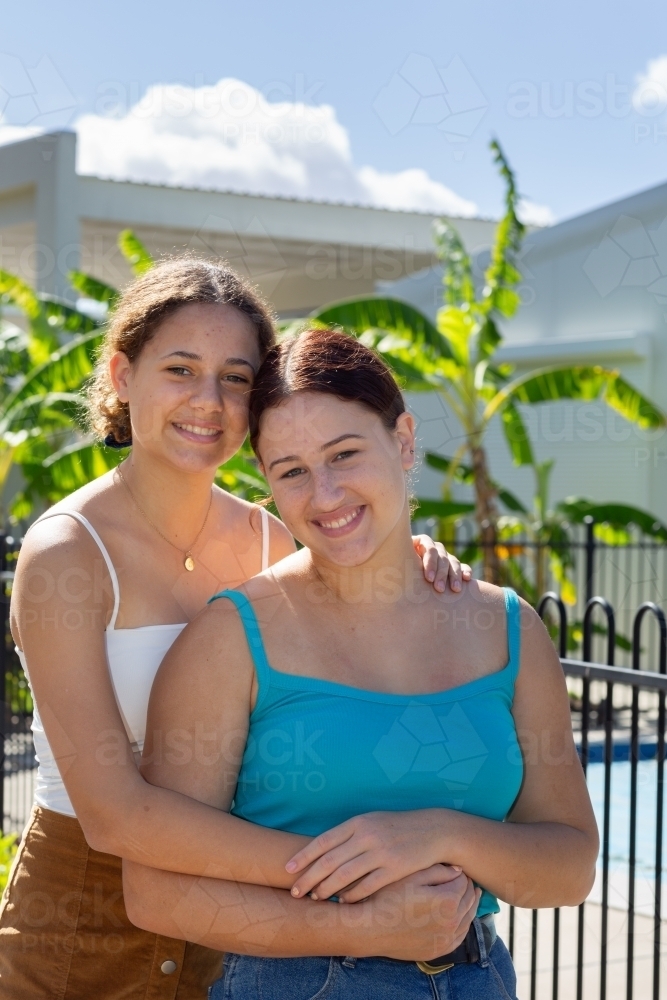 teenage sisters leaning heads together - Australian Stock Image