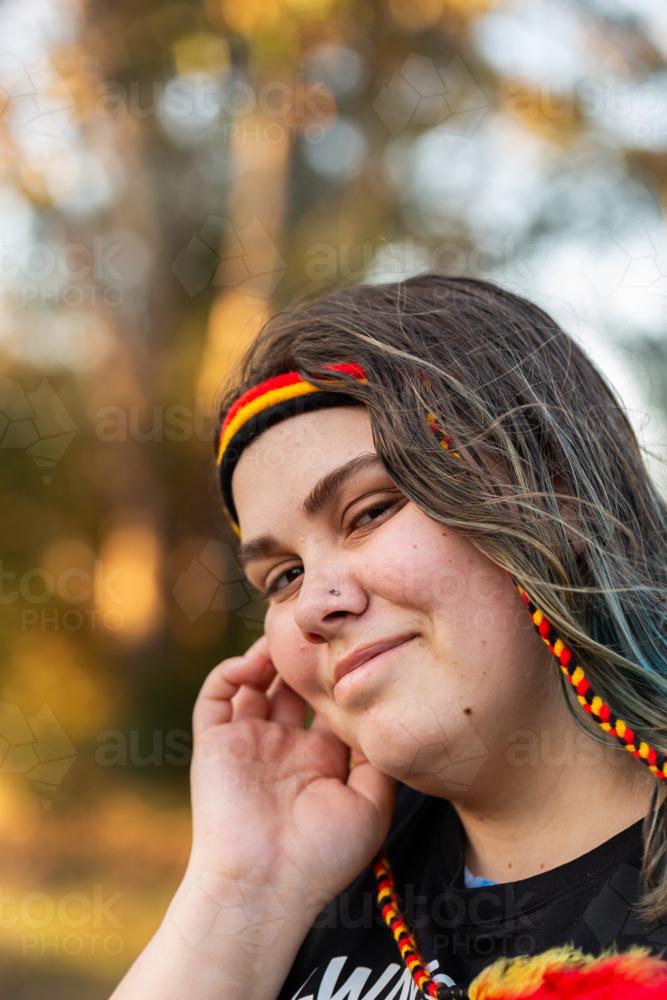 Teenaged Aboriginal girl with red yellow and black headband - Australian Stock Image