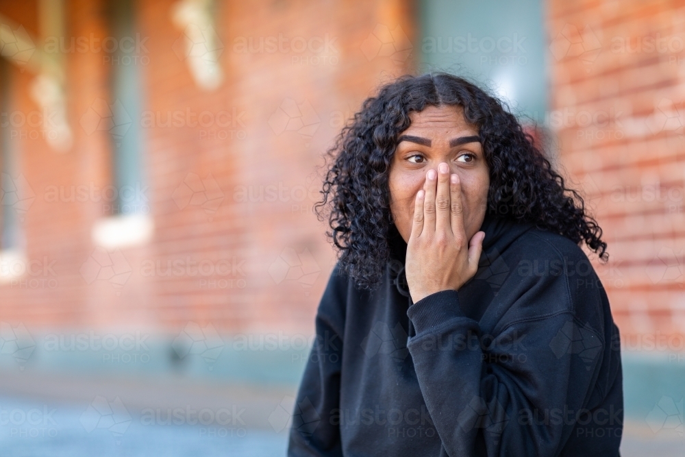 teenager being surprised with hand up to face - Australian Stock Image