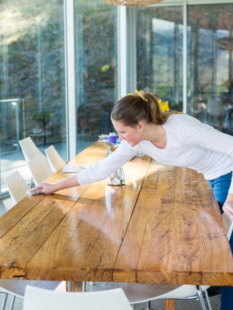 teenager cleaning the dining table - Australian Stock Image
