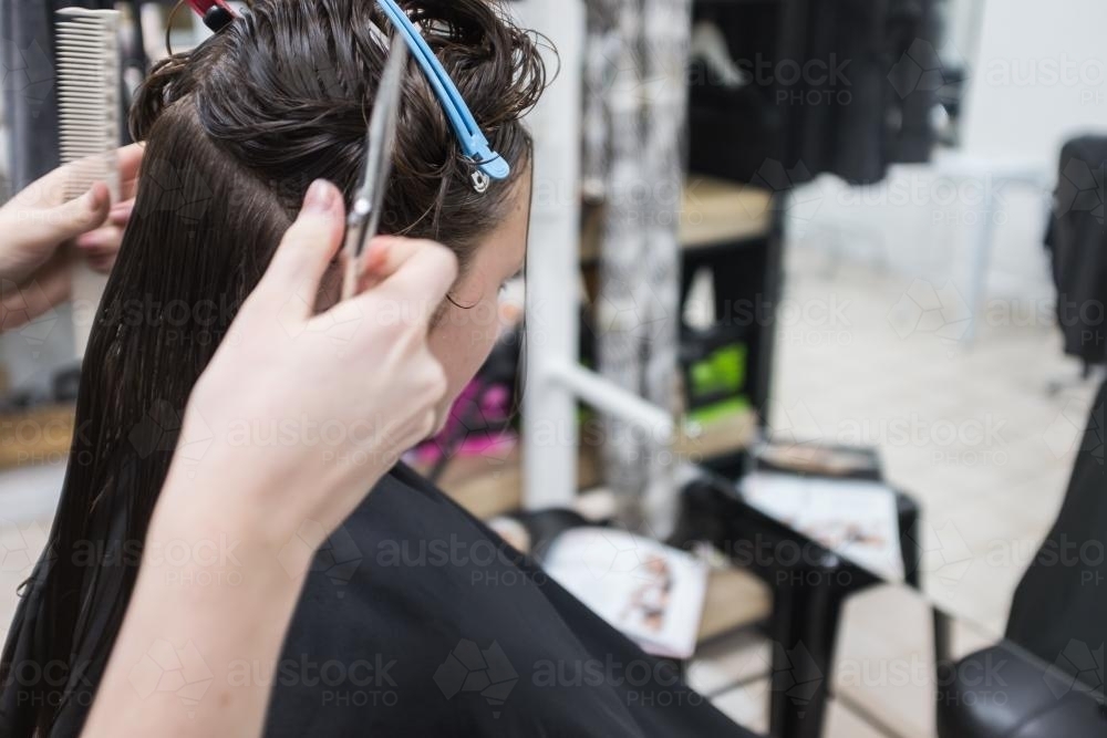 Teenager getting her hair cut at the hairdresser - Australian Stock Image