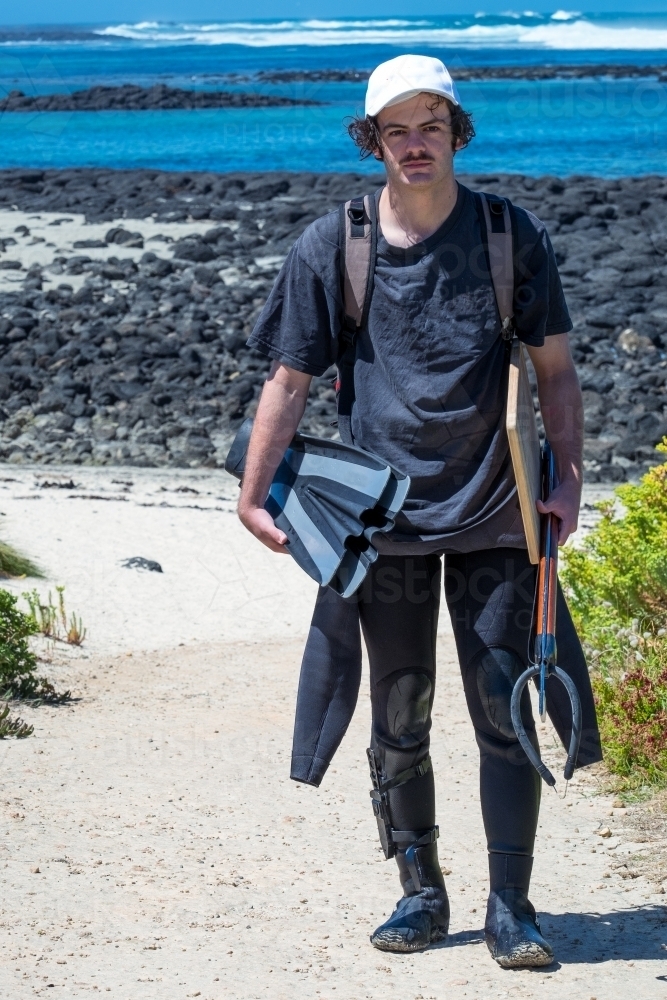 Teenager heads home after a dive with his spear gun - Australian Stock Image