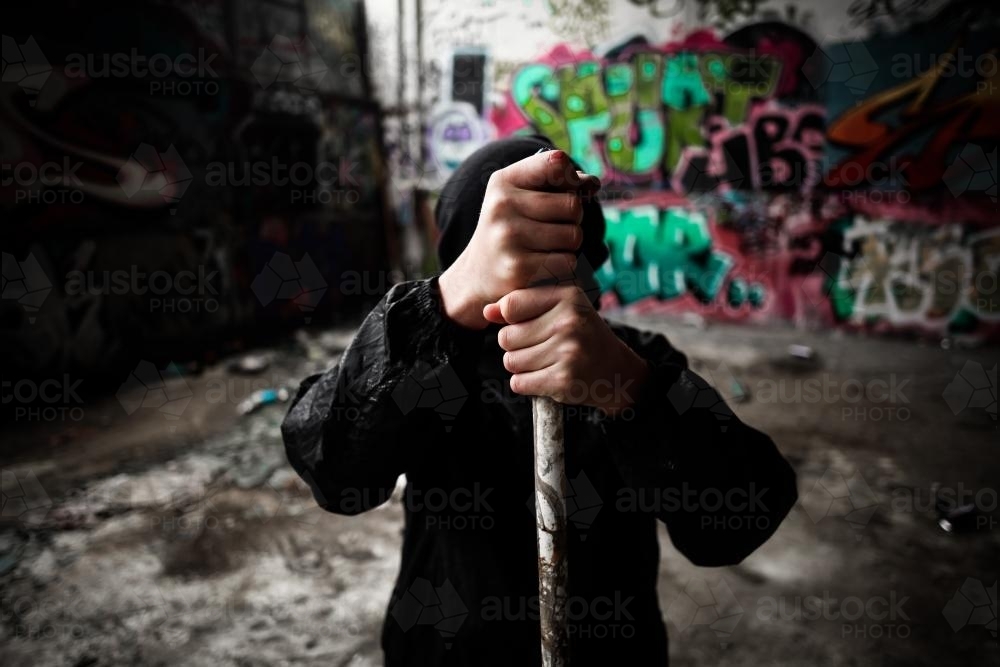Teenager holding pipe in a pose of strength and defiance - Australian Stock Image