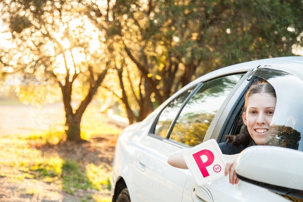 Teenager holding provisional P1 plate out car window - Australian Stock Image