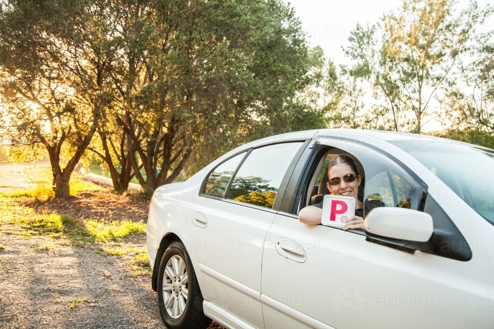 Teenager holding provisional P1 plate out car window - Australian Stock Image
