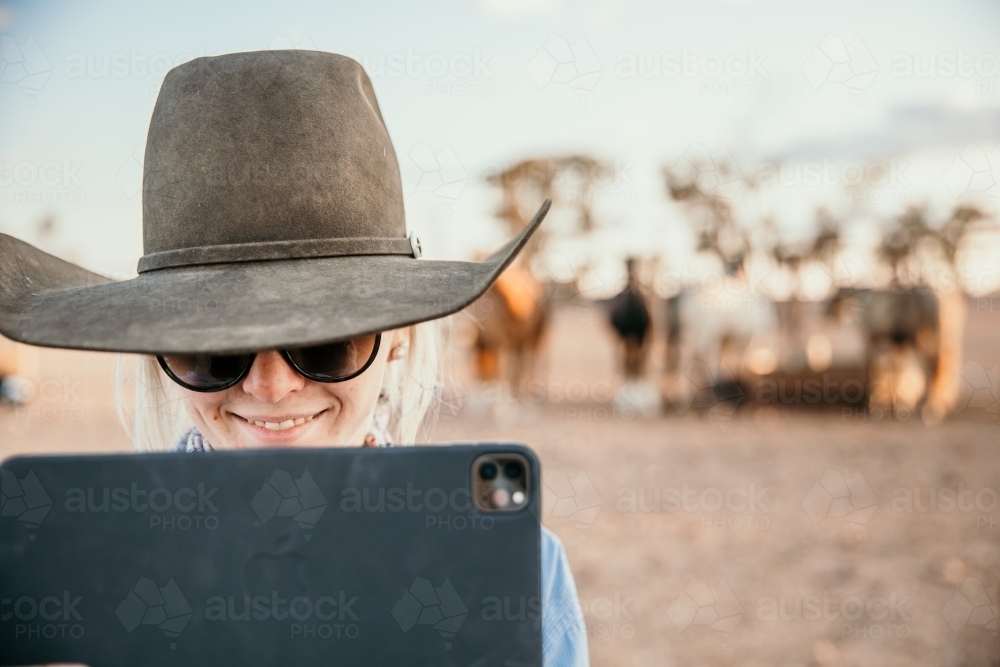 Teenager looking at iPad outdoors smiling - Australian Stock Image