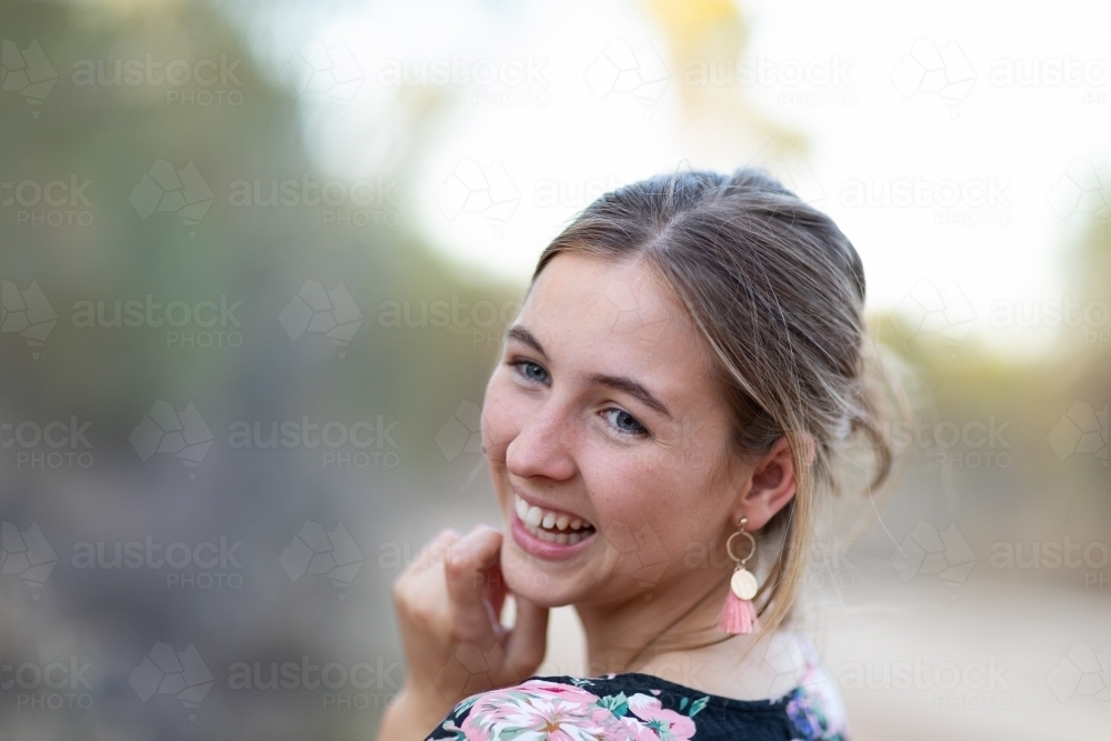 teenager looking over shoulder and laughing - Australian Stock Image