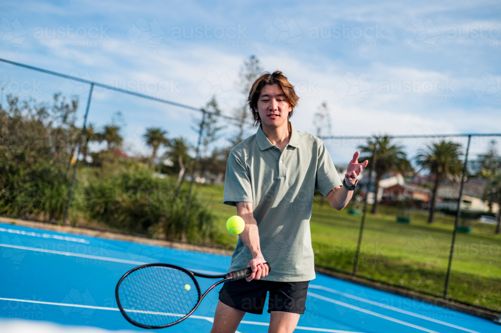 Teenager man playing tennis on a sunny day in Sydney - Australian Stock Image