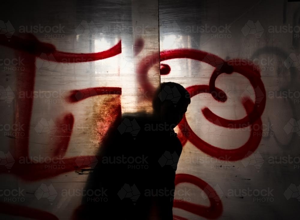 Teenager silhouette peaking from behind plastic sheeted doors - Australian Stock Image