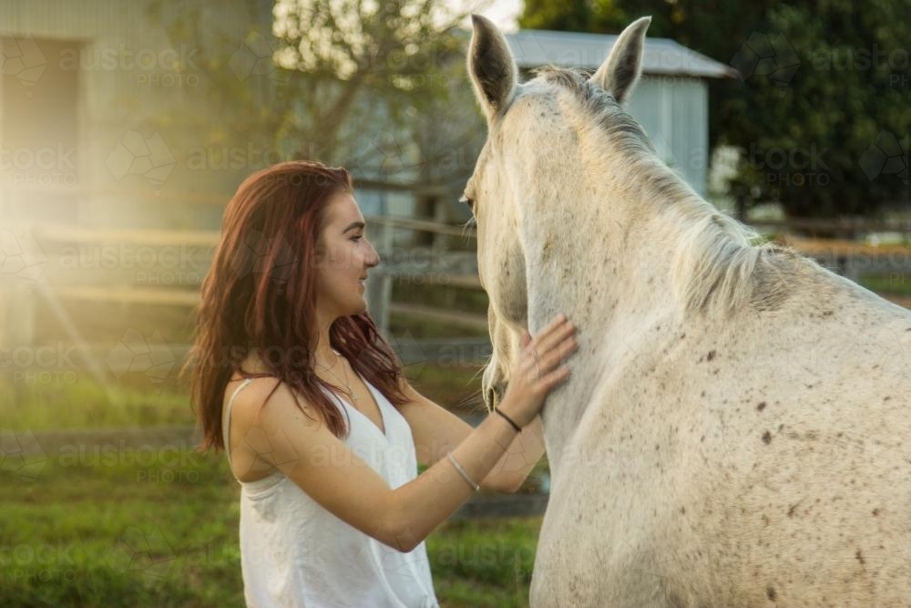 Teenager standing next to her horse - Australian Stock Image