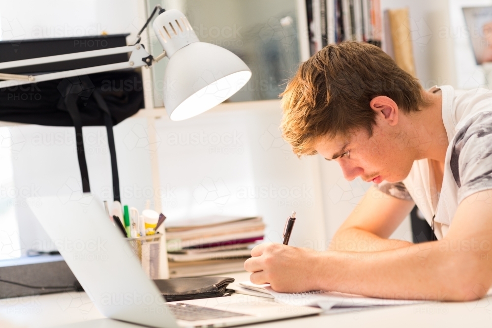 Teenager studying at desk - Australian Stock Image