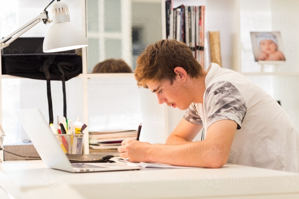 Teenager studying at desk - Australian Stock Image