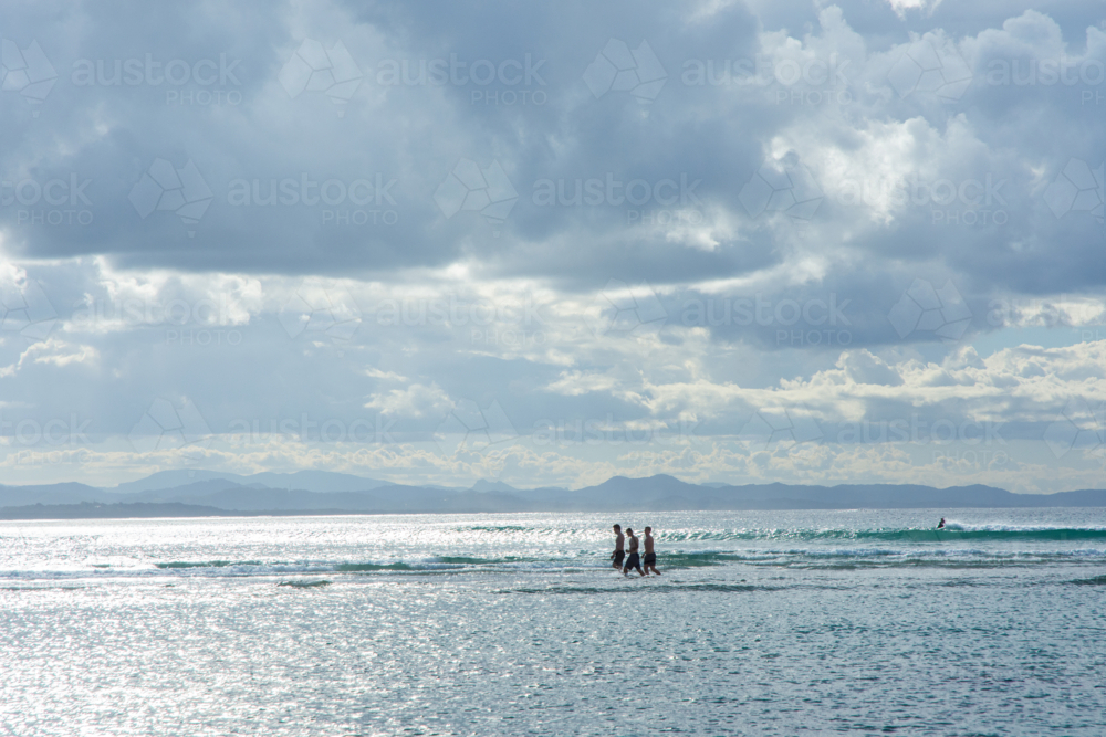 Teenagers walking in water at Byron Bay - Australian Stock Image