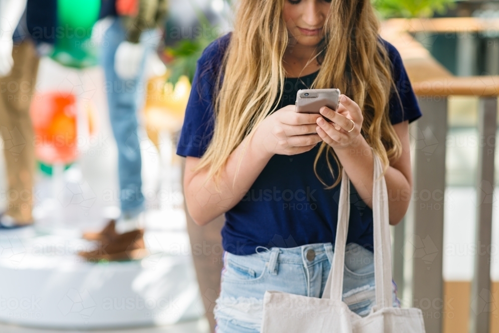 teens at the mall, using phone - Australian Stock Image