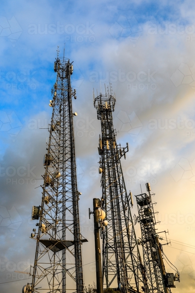 Telecommunications towers against cloudy sky - Australian Stock Image