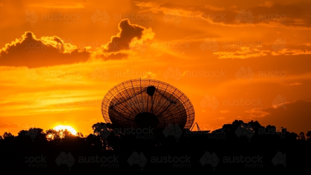 Telescopic Dish against a red fiery sunset sky - Australian Stock Image