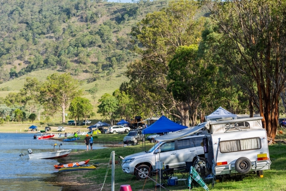 Tents and caravans set up along the waterside at Lake St Clair - Australian Stock Image