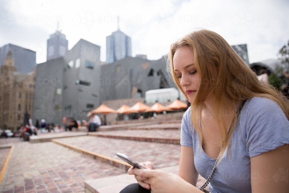 Texting in Federation Square : Austockphoto Texting in Federation Square - Australian Stock Image