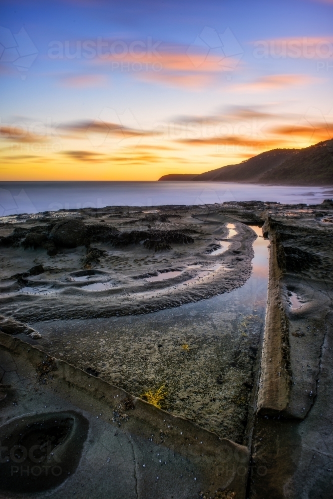 Textured, rocky coastline at sunset - Australian Stock Image