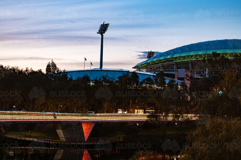 The Adelaide Riverbank Precinct Bridge crossing the River Torrens towards Adelaide Oval in evening - Australian Stock Image