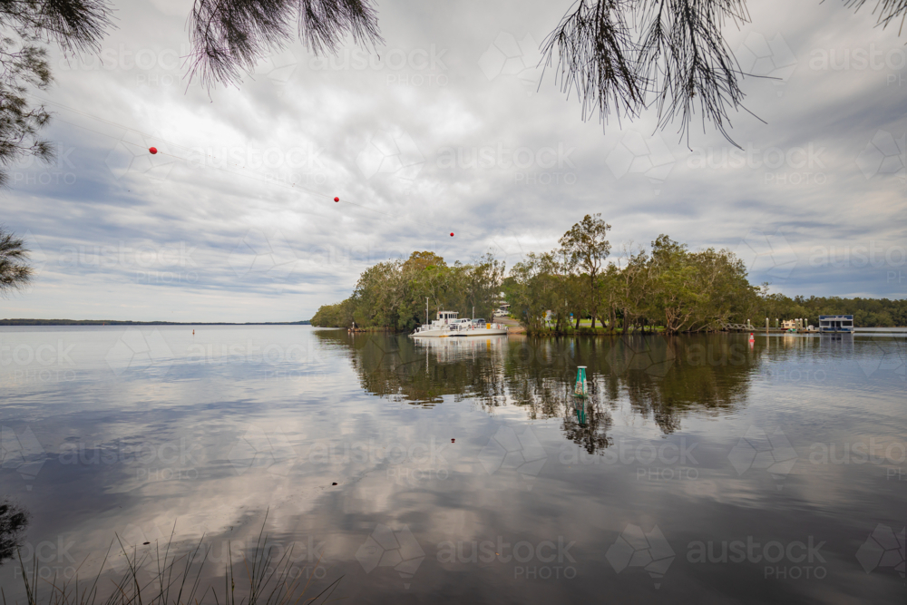 The Bombah Point Ferry carrying a vehicle across water - Australian Stock Image
