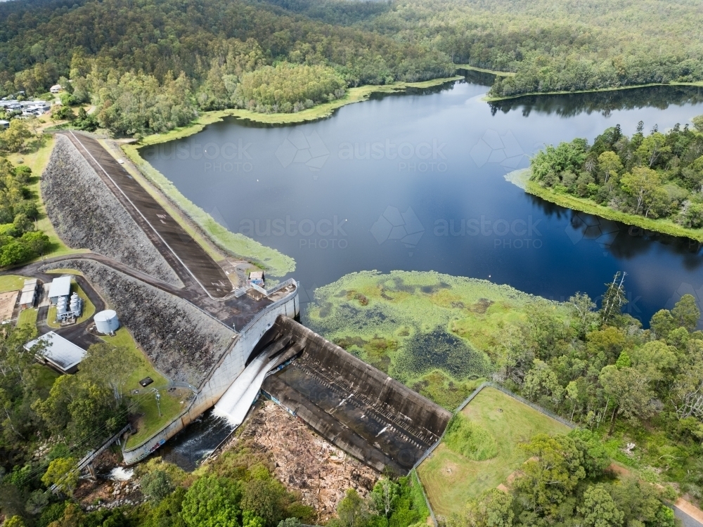 The Enoggera Reservoir, with flowing spillway, in the Brisbane suburb of The Gap - Australian Stock Image