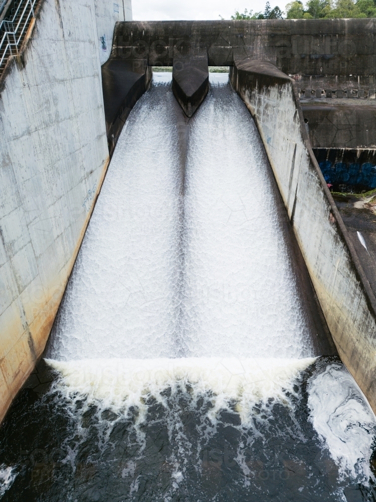The Enoggera Reservoir, with flowing spillway, in the Brisbane suburb of The Gap - Australian Stock Image
