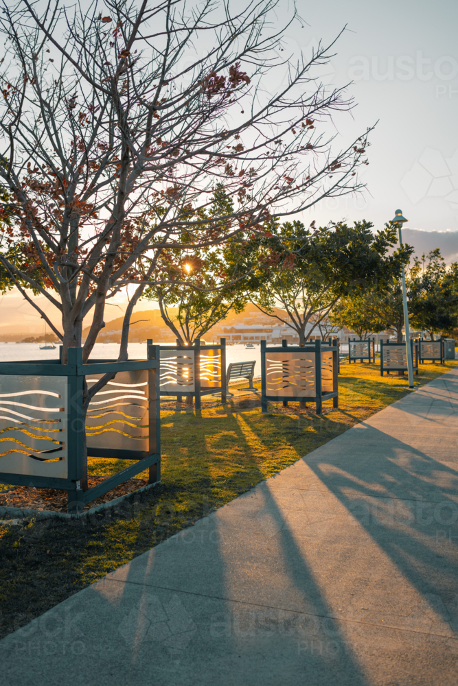 The footpath through Belmont Lions park on the shoreline of Lake Macquarie at sunset - Australian Stock Image