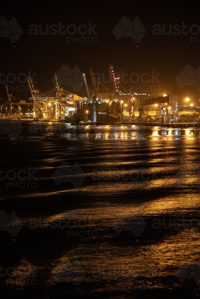 The industrial lighting emitted from The Port of Brisbane operating at night. - Australian Stock Image
