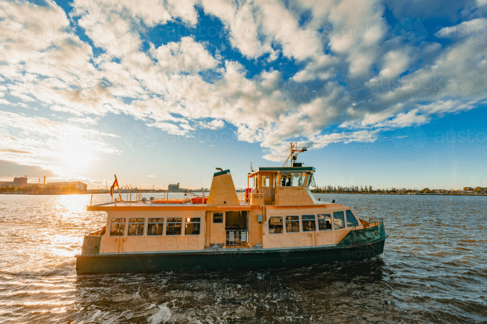 The Newcastle-Stockton ferry leaving Queens Wharf to cross the Hunter River at sunset - Australian Stock Image