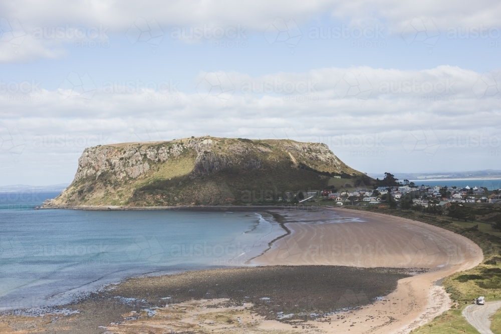 The Nut, Stanley in the background with clouds and blue sky and the beach in the foreground - Australian Stock Image