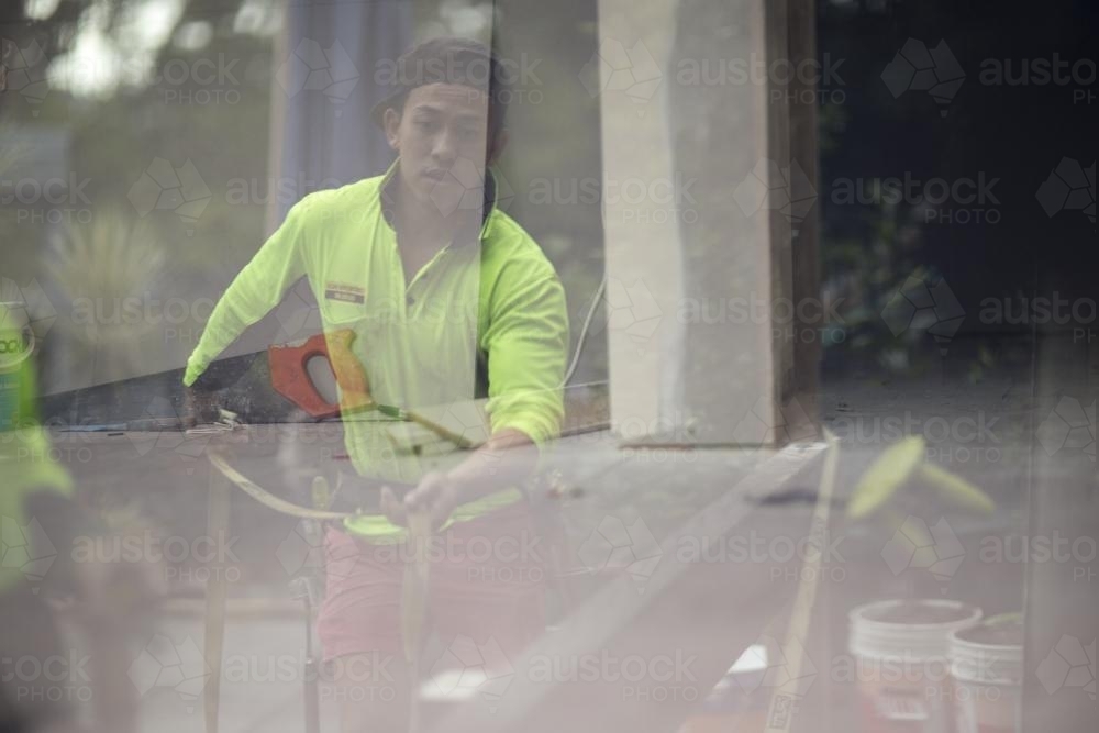 The reflection of a tradesman in the process of building a deck - Australian Stock Image