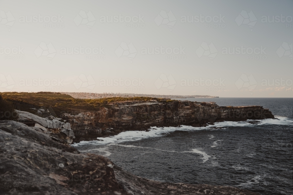 The rocky cliffs of Magic Point on the coastal walk at sunset. - Australian Stock Image