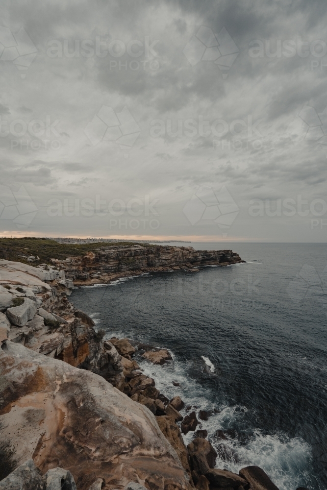 The rocky cliffs of Magic Point on the coastal walk at sunset. - Australian Stock Image