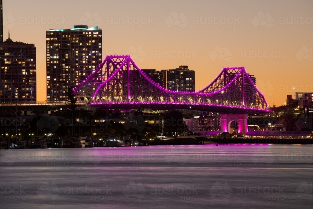 The Story Bridge illuminated magenta/pink after the sun has set - Australian Stock Image