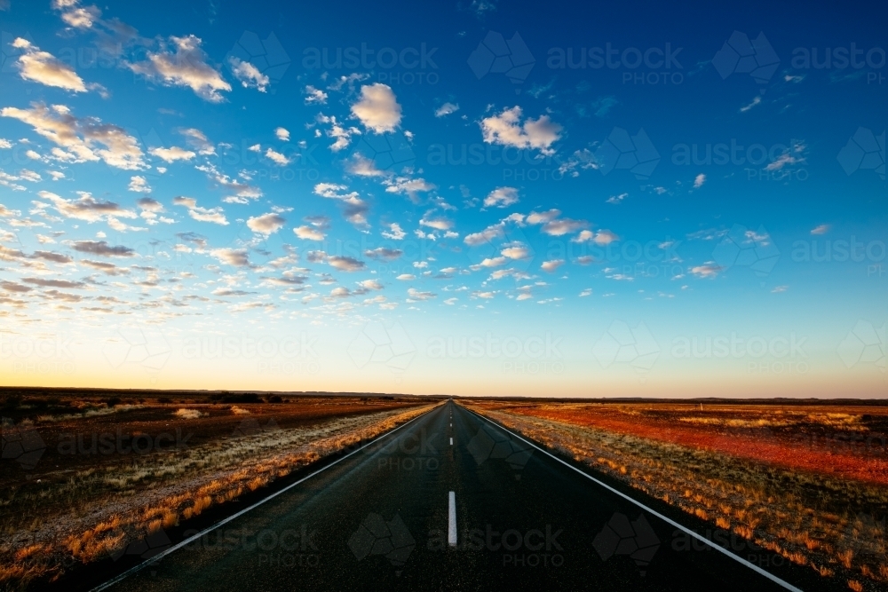 The Stuart Highway disappears into the flat horizon in central Australia. - Australian Stock Image