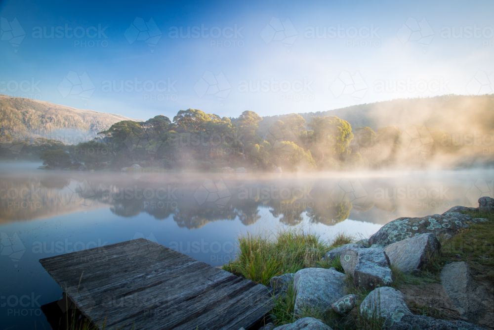 The sun rises over Lake Crackenback on a cold autumn morning in New South Wales, Australia - Australian Stock Image