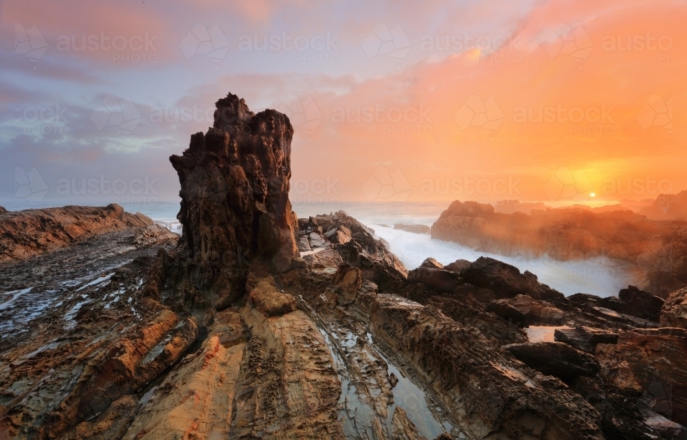 The sun rises over the ocean from rocky coastline in Australia : Austockphoto The sun rises over the ocean from rocky coastline in Australia - Australian Stock Image