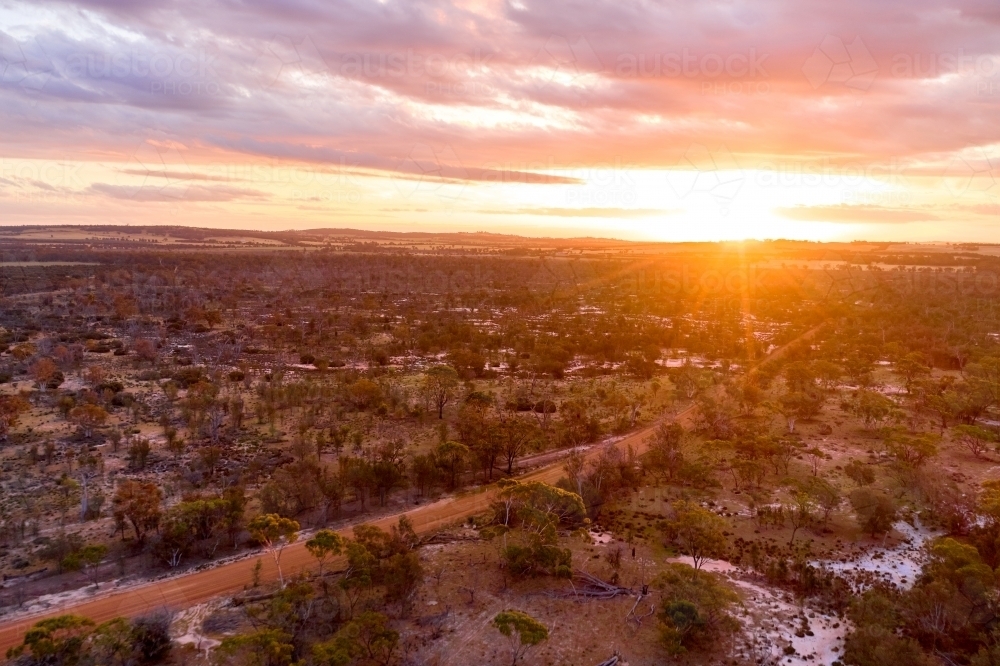 The sun setting over low-lying salty landscape in rural Western Australia. - Australian Stock Image