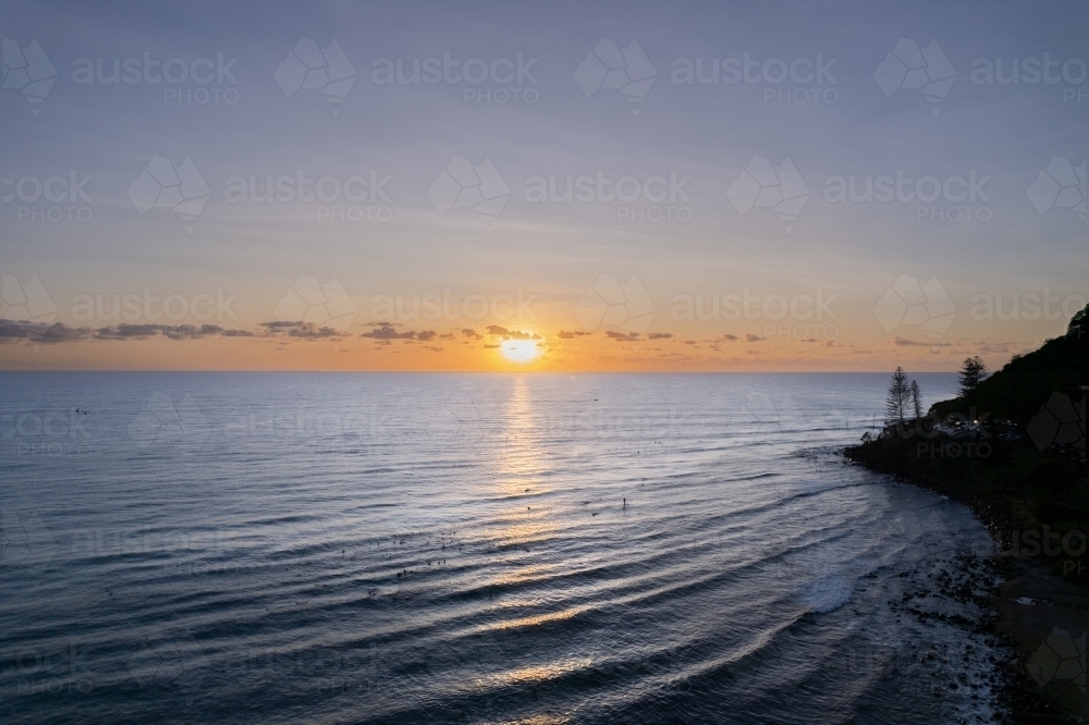 The sunrise over the ocean with  paddle boarders waiting for the waves - Australian Stock Image