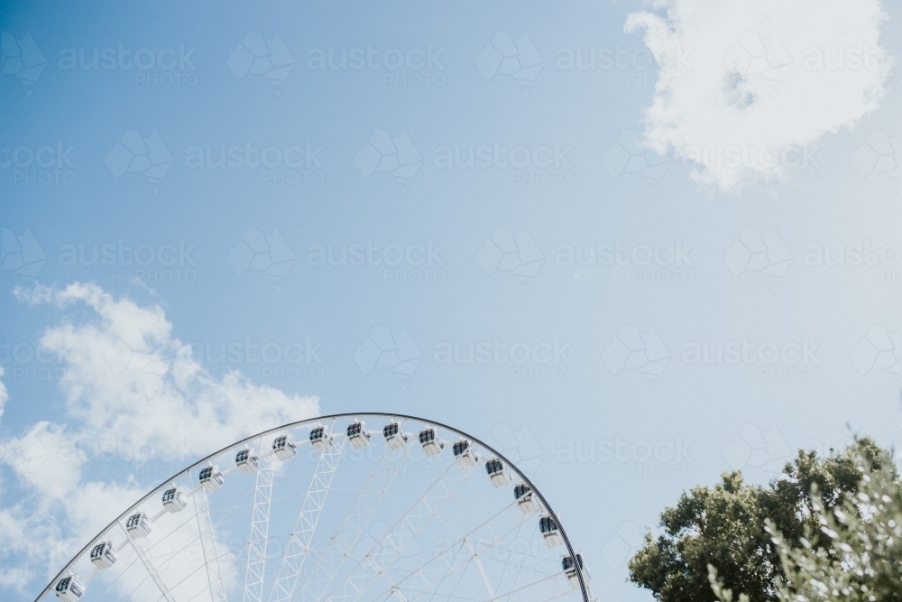 The top of a ferris wheel and tree against  the sky - Australian Stock Image