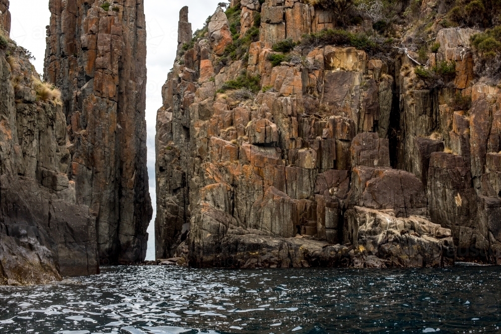 The towering cliffs of Cape Hauy in Tasmania seen from the water - Australian Stock Image