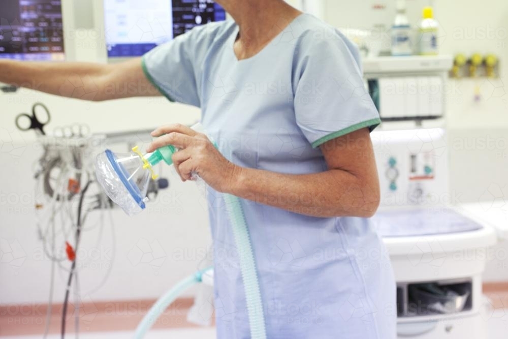 Theatre nurse holding face mask in the operating theatre of a private hospital - Australian Stock Image