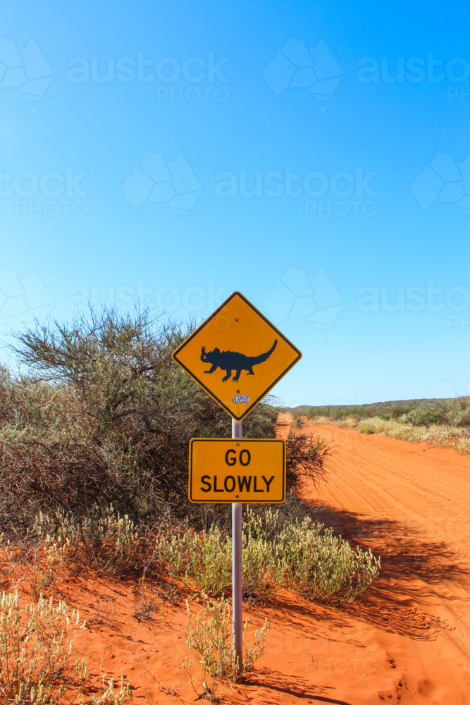 Thorny devil road sign on red dirt road - Australian Stock Image