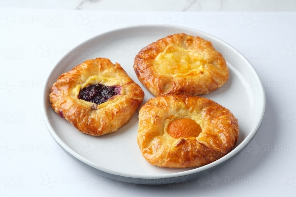 Three Danish pastries on plate - Australian Stock Image
