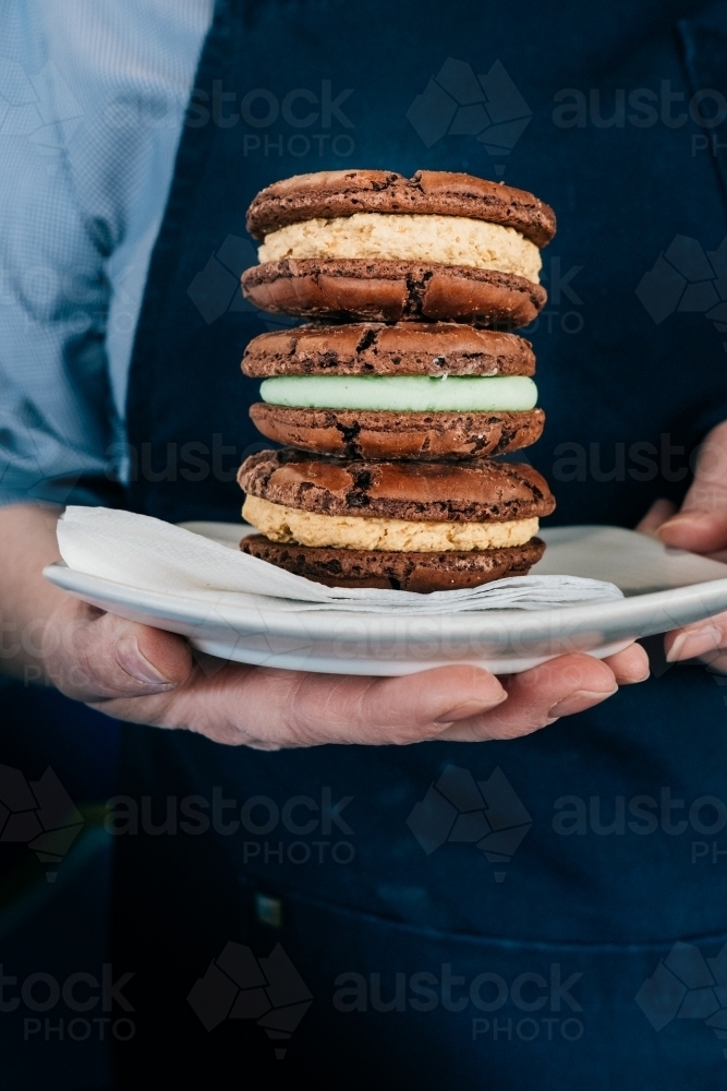 Three delicious biscuits stacked on a plate. - Australian Stock Image