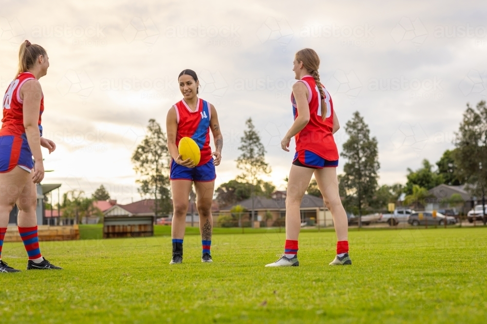 three female football players doing handball drill at training - Australian Stock Image
