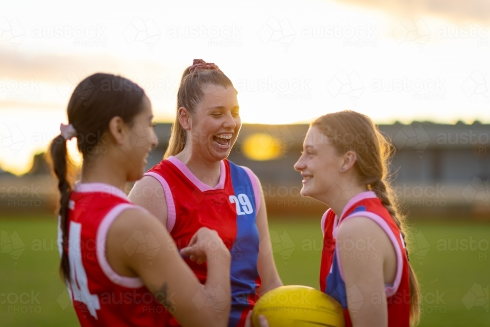 Three female  football players talking  and laughing on the field - Australian Stock Image